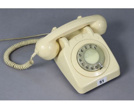 A vintage cream plastic telephone.