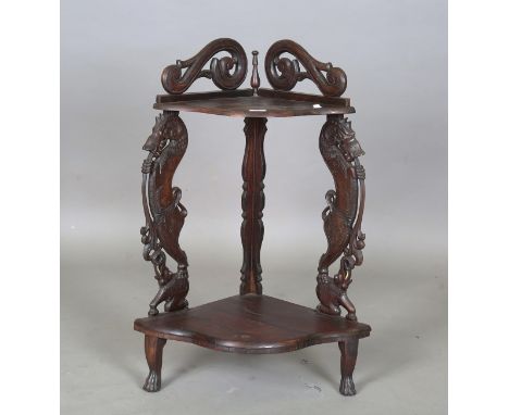 A 20th century Burmese hardwood two-tier corner shelf, the two supports finely carved with beasts standing on elephants, heig