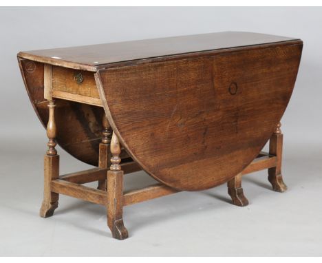 An 18th century oak oval drop-flap dining table, fitted with a single drawer and raised on a gateleg base with breganza feet,