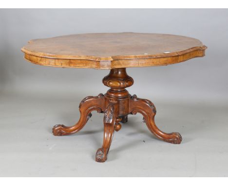 A Victorian burr walnut tip-top breakfast table of oval serpentine outline, on a carved baluster column and four cabriole leg