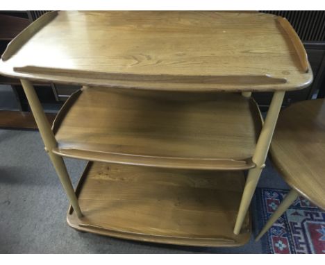 A light Ercol tea trolley with three tiers .