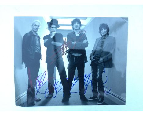 An unframed signed photo of The Rolling Stones, approx 25cm x 20cm. Shipping category A.