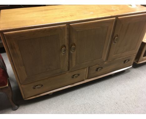 A Ercol sideboard with three cupboards and two drawers .