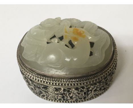 A Chinese white metal and jade mounted box of oval shape with a detachable lid the side with blind fretwork decoration with f