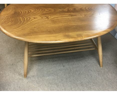 A Ercol occasional table the oval top on turned legs United by a under tier .
