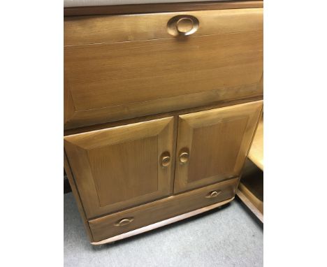 A light Ercol bureau the fall front above a pair of cupboard doors.With drawer under .