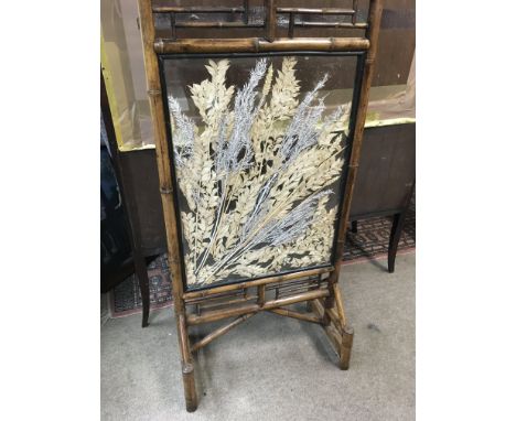A bamboo fire screen the centre panel inset with foliage.
