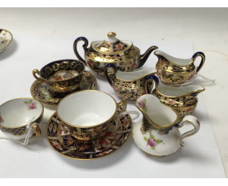 A Collection of miniature teapotâ€™s milk jugs and cups and saucers including Royal Crown Derby and Minton .