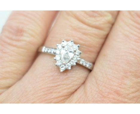 Diamond cluster ring, the certificated central pear cut diamond estimated as G-H in colour and SI 1-2 clarity, bordered with 
