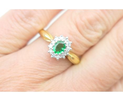 Emerald and diamond cluster ring, the oval cut emerald of approx. 0.25ct, bordered with small brilliants set in 18ct white go