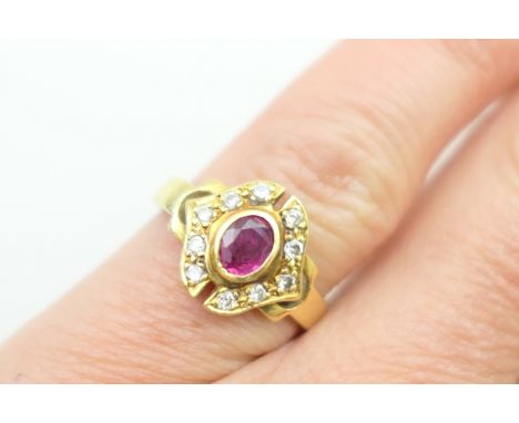 Ruby and diamond cluster ring, the oval cut ruby of approx. 0.5ct, collet set and bordered with tiny brilliant cut diamonds, 