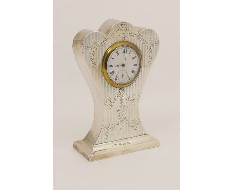 George V silver dressing table clock, Birmingham 1912, waisted, lobed form, the case engraved with foliate garlands enclosing