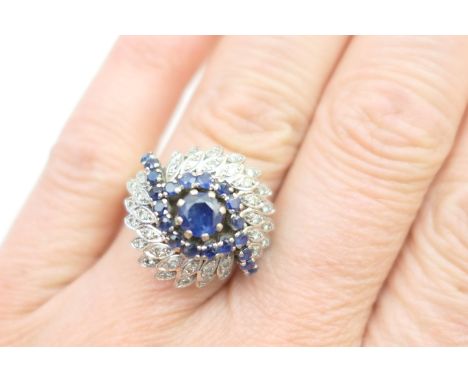 Sapphire and diamond cluster ring, the sapphires set in an 'eye' formation centred with a brilliant cut stone of approx. 0.5c