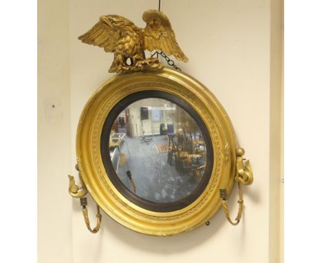 Regency giltwood convex wall mirror, with carved eagle surmount, cavetto moulded cornice, two additional light brackets, 57cm