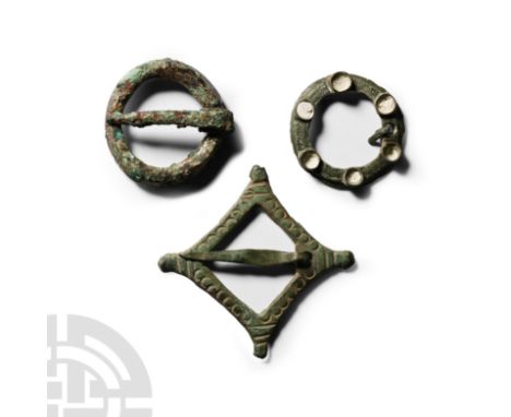 Circa 14th-16th century A.D. Comprising: a plain ring brooch; one with six turrets; and one lozenge-shaped decorated with sta