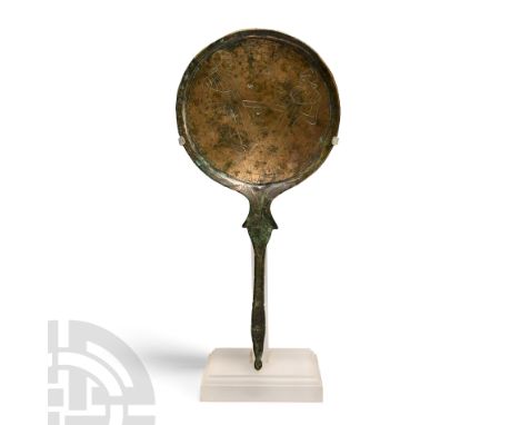 Circa 5th century B.C. Disc mirror with handle comprising: slightly dished mirror with thick rim and low-relief image of two 