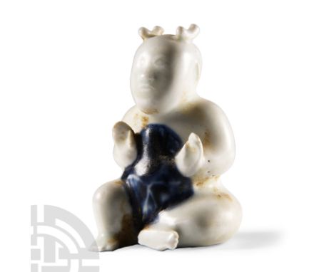 Circa 1730 A.D. A blue-glazed ceramic figure of a young child, seated with blue patch to the chest and stomach.  104 grams, 8