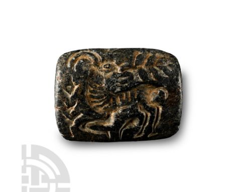 Circa 2000 B.C. Carved chlorite bifacial seal with incuse image to each broad face: coiled serpent-body with facing beast-hea
