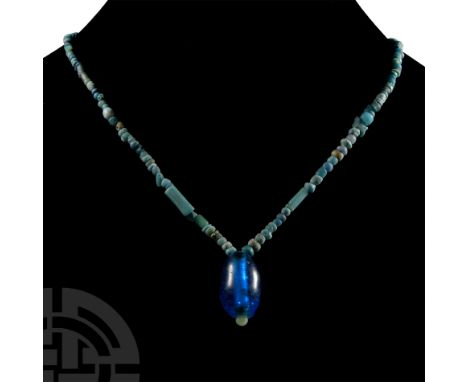 3rd-4th century A.D. Restrung designer necklace of small and bigger light blue glass beads, the centrepiece a large fusiform 