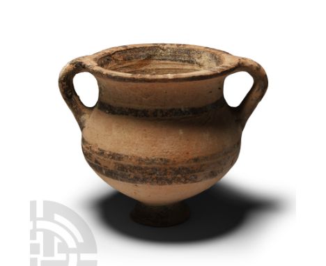 Circa 8th-5th century B.C. In black-painted geometric buffware, with wide bands of black painted decoration on the ovoid body