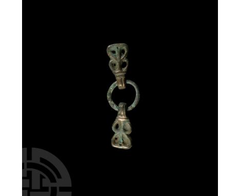 9th-11th century A.D. Composed of a ring with two free-running bars with openwork designs to the front face and bars to rever