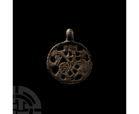 10th-11th century A.D. Composed of an discoid body with integral suspension loop; openwork design of a zoomorph enmeshed in t