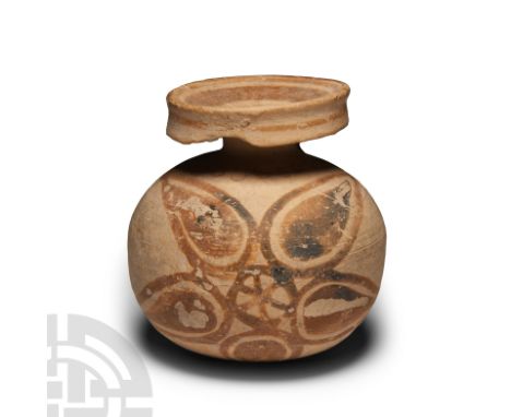 Circa 6th century B.C. Bulbous-bodied with a short neck, deep rim and strap handle; polychrome roundels to the mouth, orange 