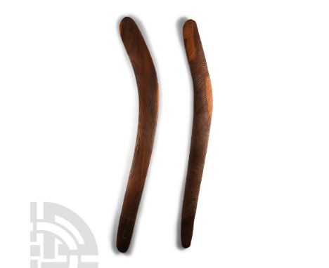 Circa 19th century A.D. Two wooden boomerangs, asymmetrical in form and with a flat underside, one carved with diagonally ban