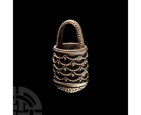 Circa 4th-7th century A.D. Decorated with filigree bands of overlapping semi-circular motifs to the sidewall; slender handle 