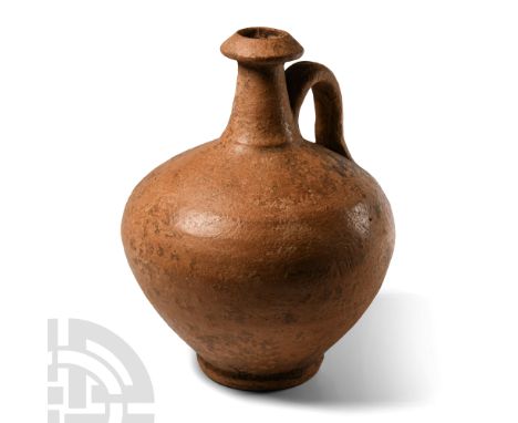 Circa 1st-2nd century A.D. With globular body and basal ring, tall columnar neck with biconical collar, single strap handle t