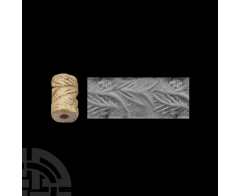 Circa 3rd millennium B.C. Of cotton-reel shape; deeply incised leaf and other motifs.  4.98 grams, 19 mm (3/4 in.).Ex propert