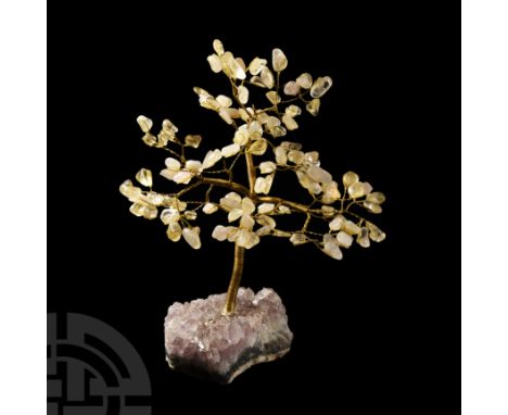 The bendable metal branches tipped with polished citrine pebbles, the trunk resting on a geode section with lavender-coloured
