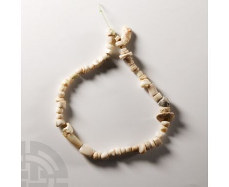 1st millennium B.C. and later. Restrung; composed of beads of various shapes and shades of cream, light blue and grey. Cf. Hu