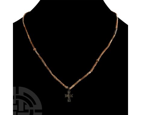 12th century A.D. or later. Restrung group of corrugated tubular and oblate beads, bronze cruciform pendant with ring-and-dot