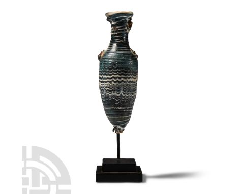 5th-4th century B.C. Elegantly proportioned vessel with marvered trails to the body, neck and mouth; handles absent; mounted 