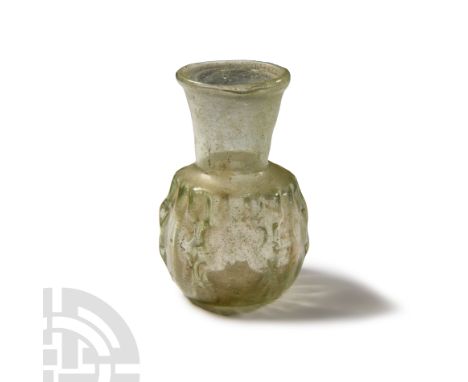 2nd-3rd century A.D. In translucent light green glass, rounded body with six pinched decorative bands, funicular neck.  39.4 