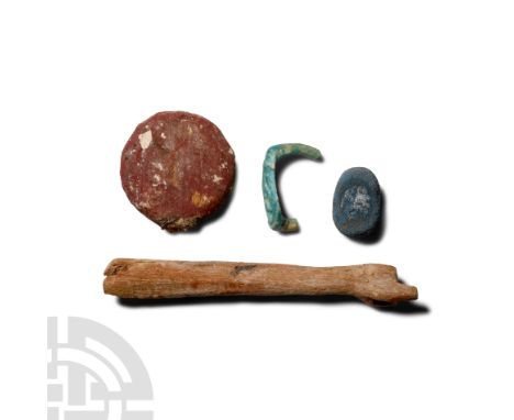 Late Period, 664-332 B.C. Comprising: a wooden arm from a diorama; a wooden sun disc with red pigment; a dark blue compositio