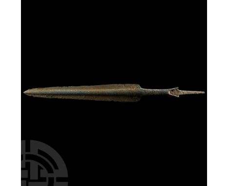 13th-12th century B.C. Showing a long tapering blade with rounded shoulders and prominent mid-rib, the tang straight and rect