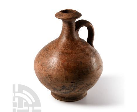 Circa 1st-2nd century A.D. With globular body, thick basal ring, tall columnar neck with biconical collar, single strap handl