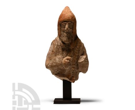 6th-5th century B.C. Modelled in the half-round, the figure wearing a conical hood with open front, detailed facial features 