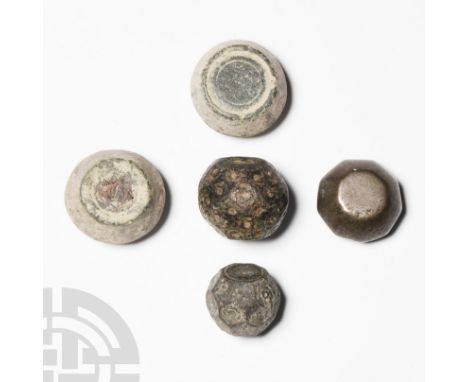 Circa 8th-12th century A.D. Mixed group of barrel-shaped, biconvex and other trade weights, some with punched markings. See W
