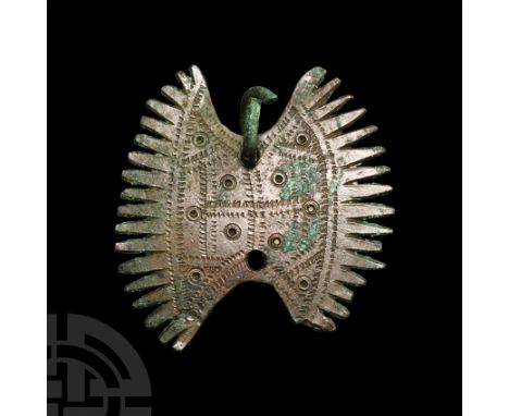 9th-11th century A.D. With segmented teeth to the edges of the lentoid plaque; ring-and-dot detailing, suspension loop. See S