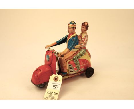 A rare Technofix GE292 tinplate friction powered Scooter. Brightly litho detailed with rider and female passenger, with dog i