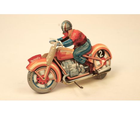 A Technofix GE255 tinplate clockwork racing motorcycle. Brightly coloured in orange with litho detailing, wheels with Metzele
