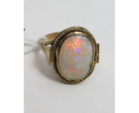 An unmarked gold ring set with an oval opal