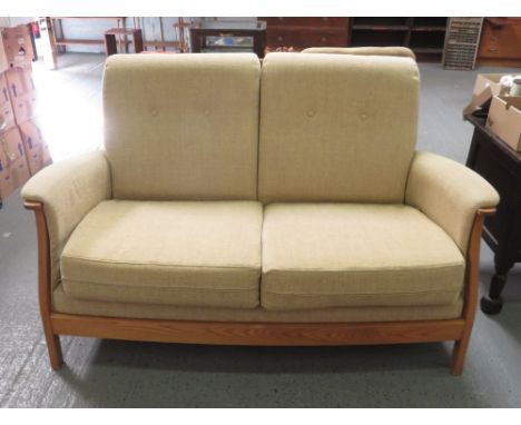 An Ercol two seater settee with lightwood frame and buttoned back cushions
