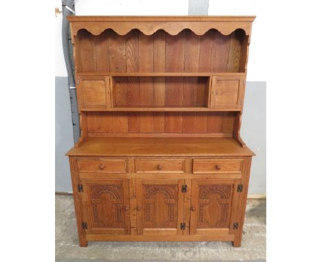 An Old Charm type light oak dresser the upper section with shelves and small cupboards, the base with three short drawers abo