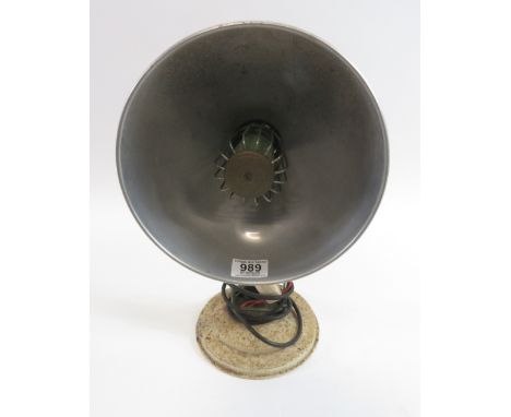 A vintage wall heater with cast metal circular wall mount and aluminium shade