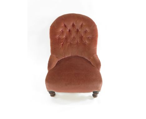 A Victorian upholstered nursing chair with button back and on low turned front supports