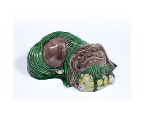 Biscuit model of a Buddhist dog and her pup Chinese, 19th Century aubergine, green and yellow glazed, with puppy nestled to t